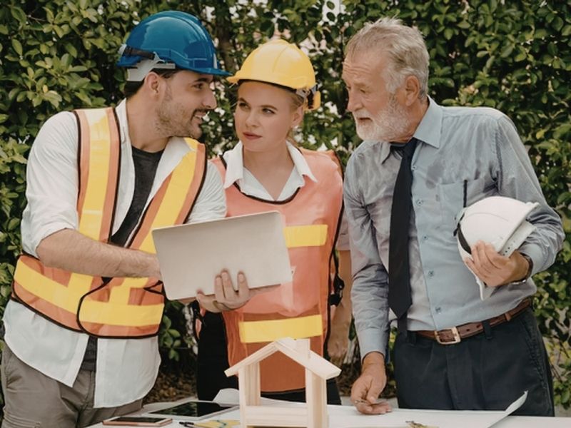Civil engineer, property owner, and project team reviewing plans during the early stages of a land development project.