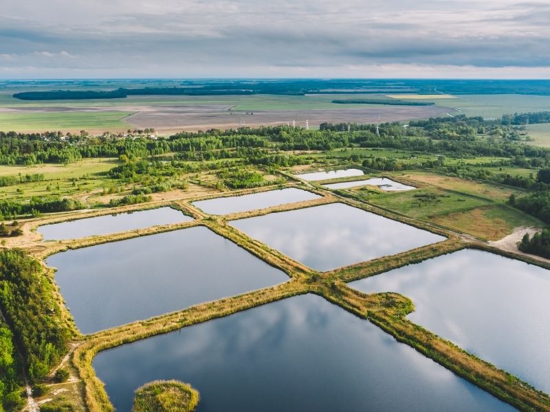 Aerial view of stormwater detention ponds and drainage basins integrated into a commercial site plan to manage runoff before architectural design and construction.